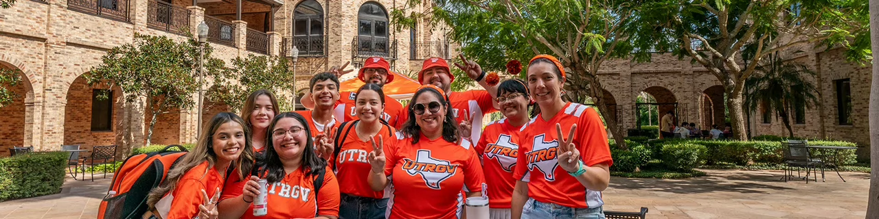 Group of students behind the Main Building in Brownsville with V's Up.