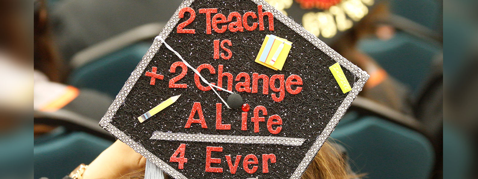 Student's graduation cap at commencement  "2 Teach is 2 Change a life 4ever"