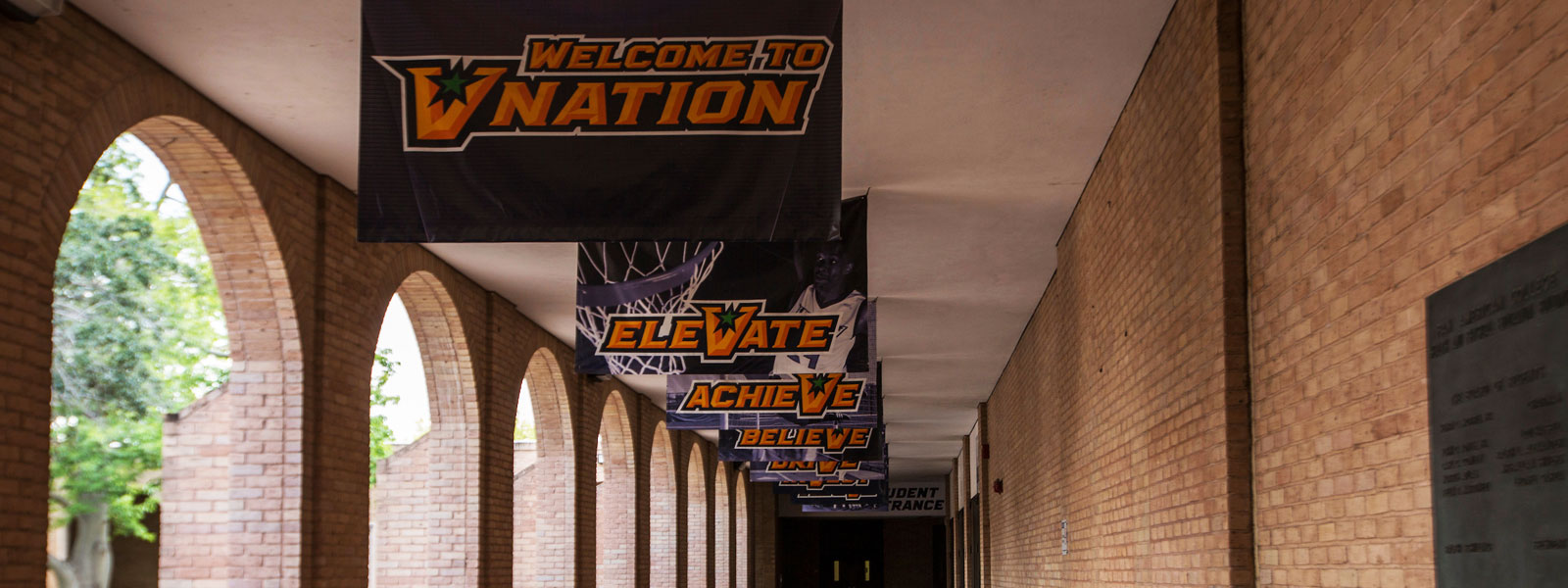 Welcome to V Nation flag hangs outside Education Complex building