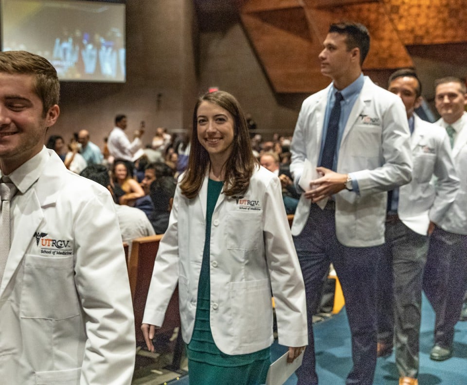 Medical students cloaked in their signature white lab coats by School of Medicine leaders
