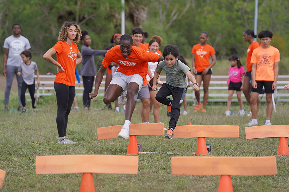 Jermarrion Stewart, a UTRGV student-athlete, racing alongside a young athlete at a free track & field clinic in Brownsville. (UTRGV Photo)