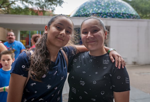 In this image, Madeline, left, and Hailey wait in line to enter the H-E-B Planetarium.