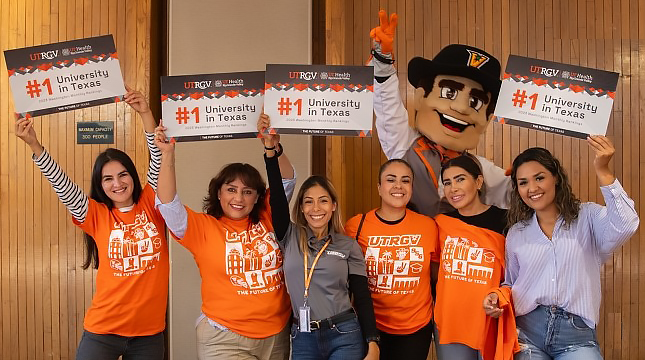 Vaquero mascot, students and staff holding #1 University in Texas signs.