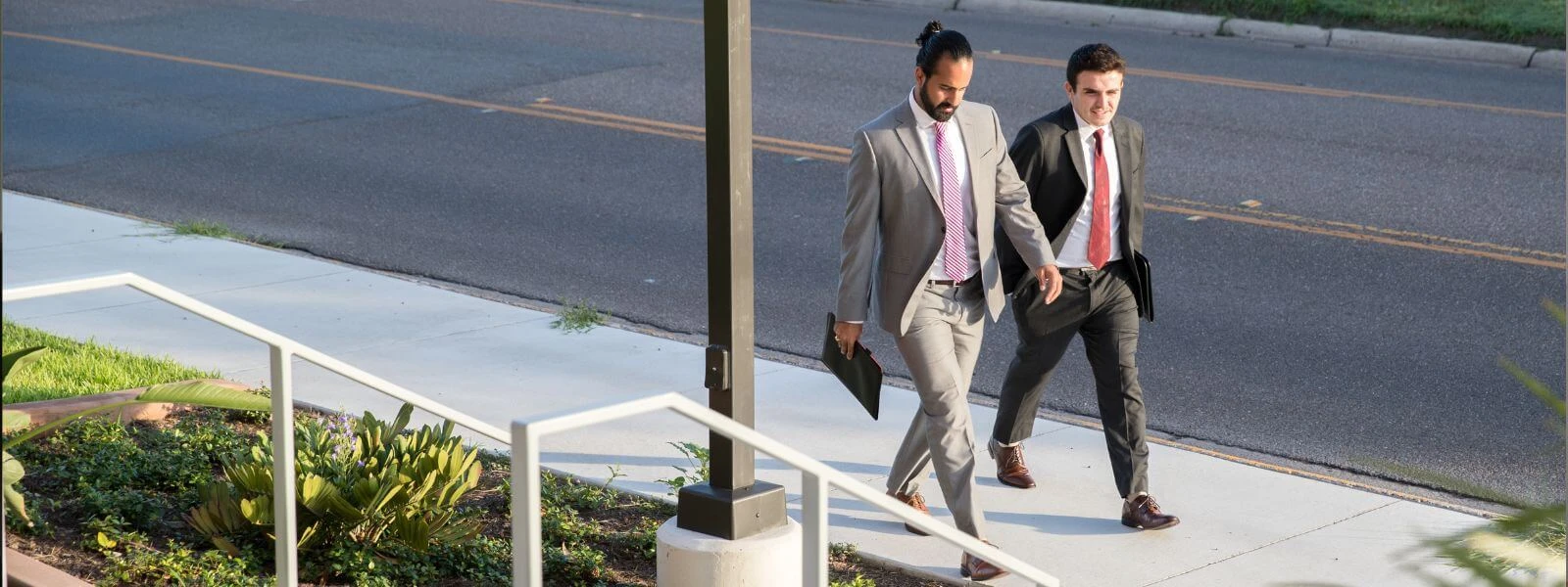 Business students in professional attire walking down sidewalk