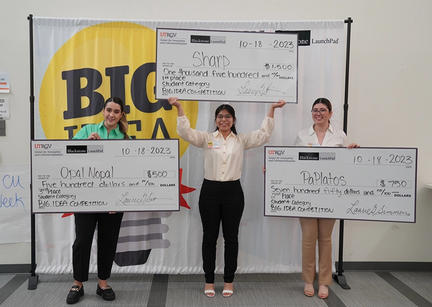 Students pose with checks after the Big Idea Competition