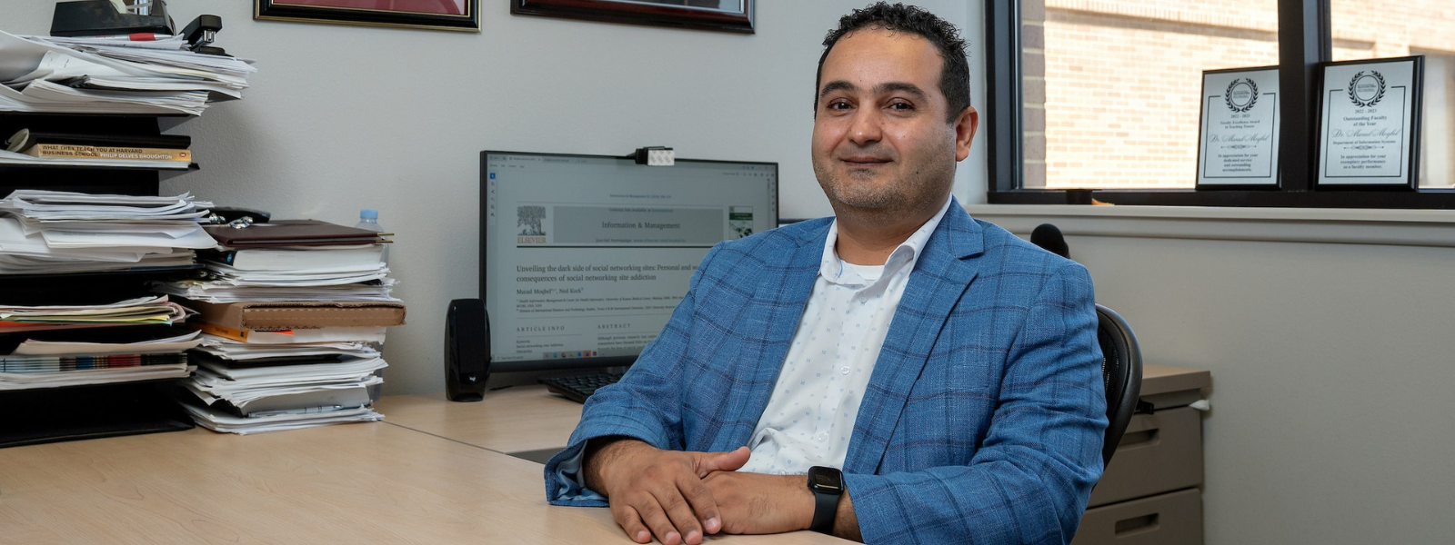 Faculty smiling in his office.