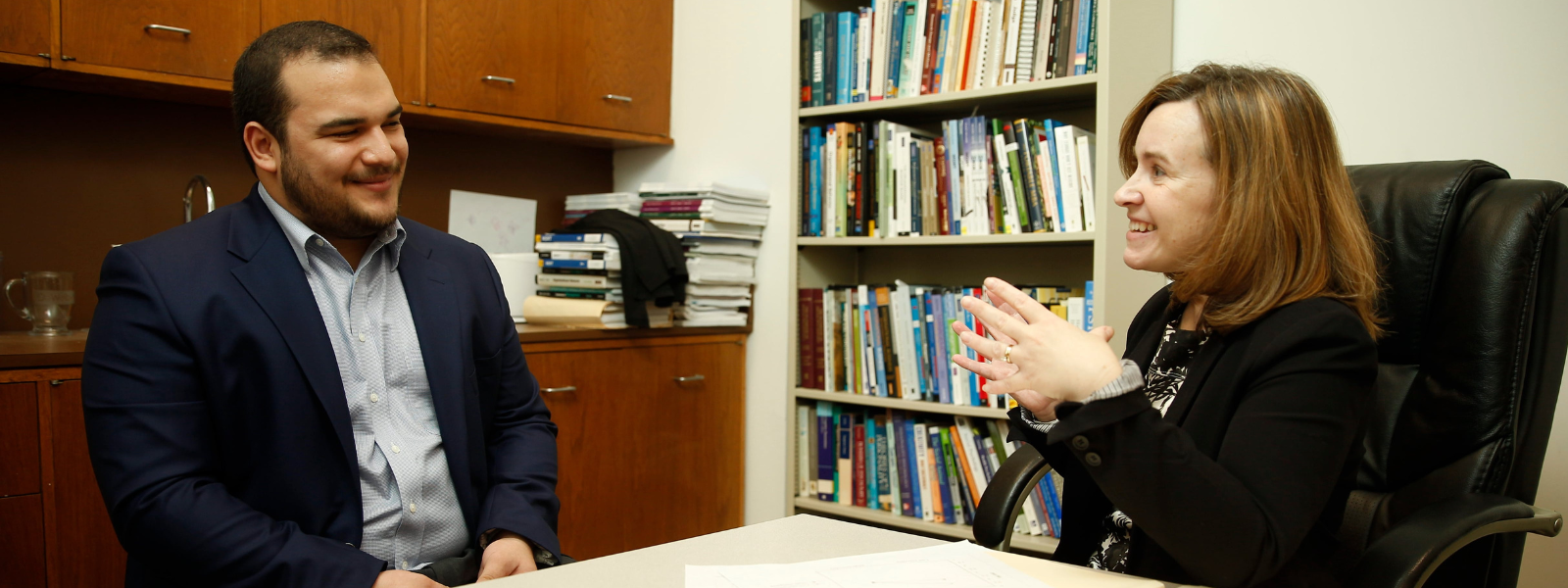 Dr. Jennifer Welbourne talking to a student in an office. 