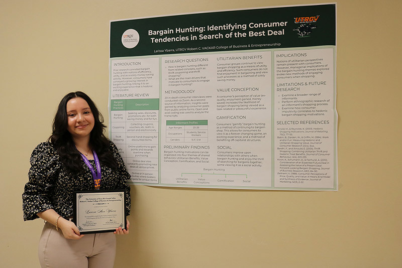 Student Larissa Ybarra holding presentation poster.