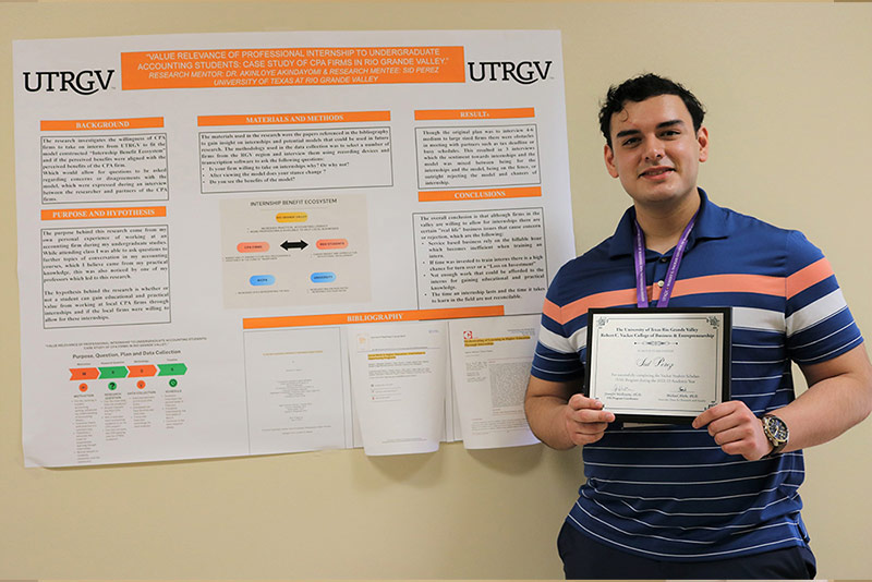 Student Sid Perez holding presentation poster.