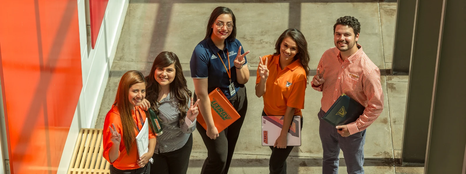 Students smiling while looking at marketing documents