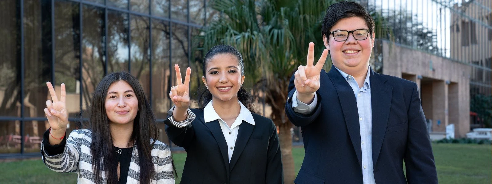 Students give V's up hand sign and smile