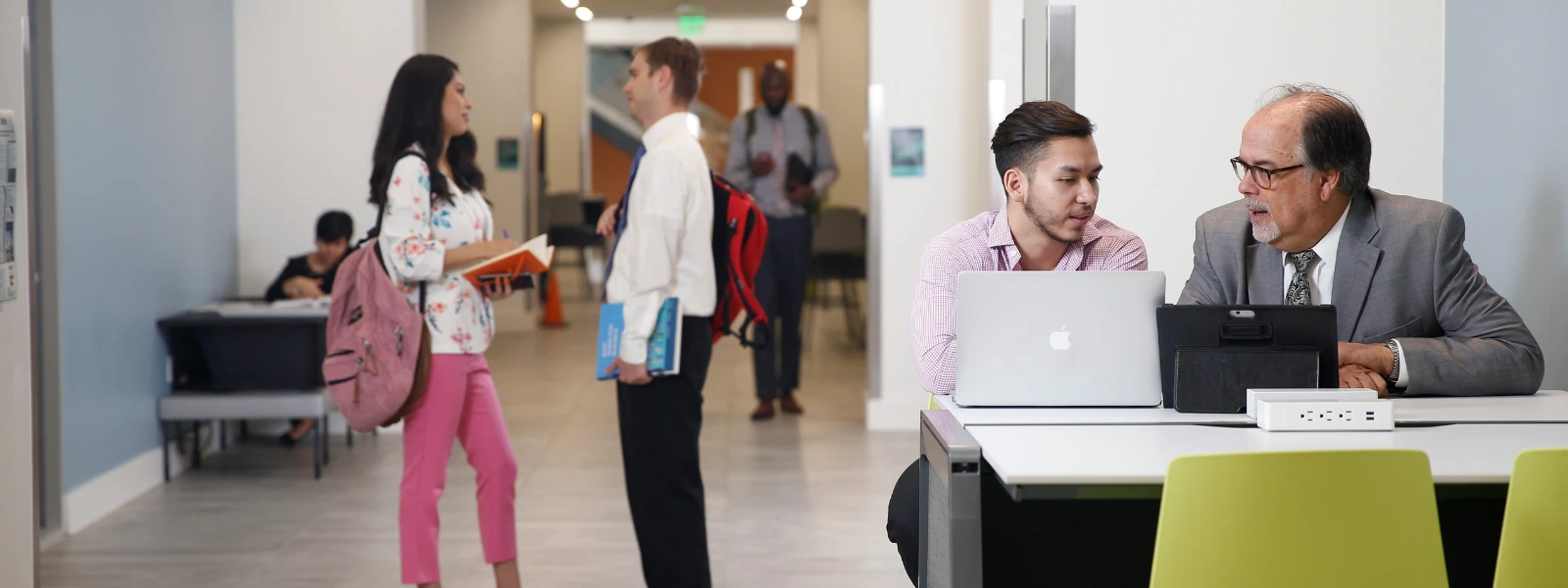 Students in discussion behind laptop